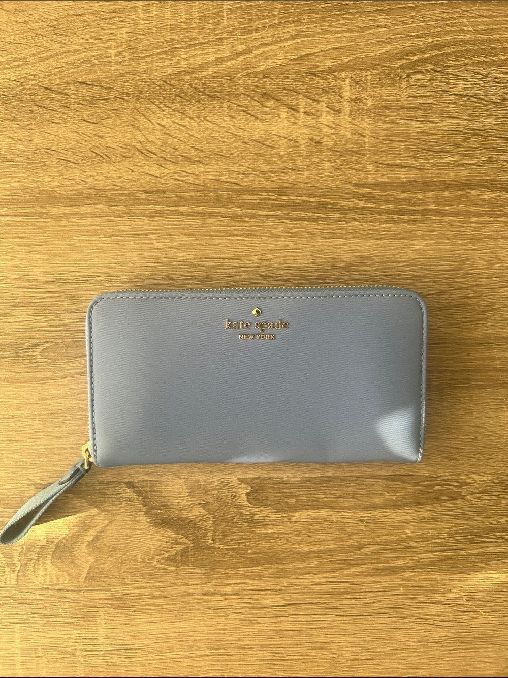 kate spade zip-around wallet in dusty periwinkle blue and gold accent hardware